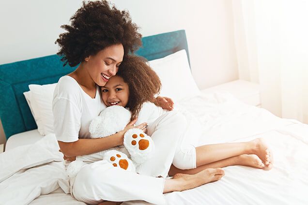 mother-daughter-cuddling-bed-air-comfort