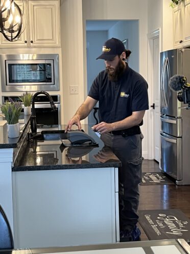 Technician taking water sample from sink for testing for hardness