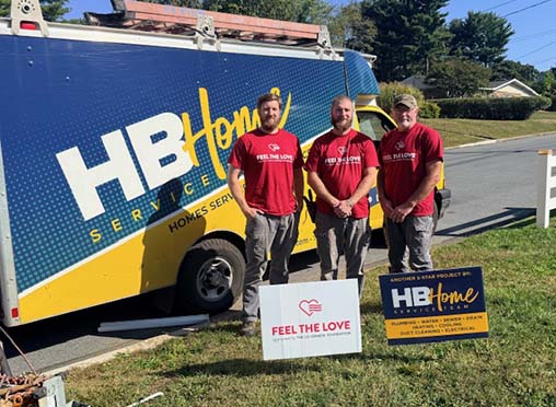 Technicians standing in front of HB Home work truck with Feel The love sign in front