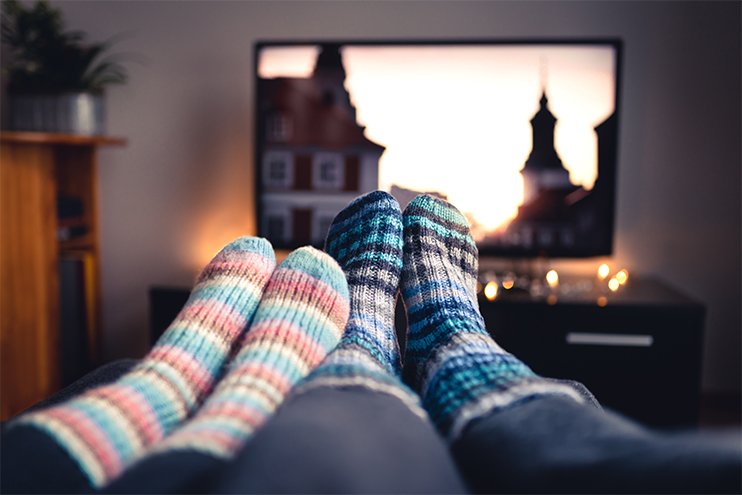 couple enjoying their cozy warm home in front of the television